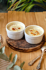 Baked porridge with cream. Side view, wooden background