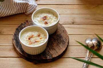 Baked porridge with cream. Side view, wooden background