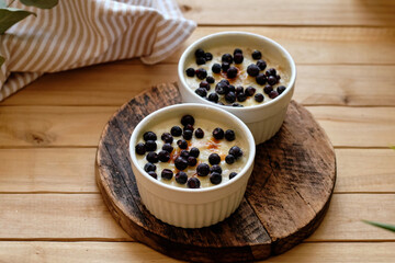 Baked porridge with cream and blueberries.Side view, wooden background