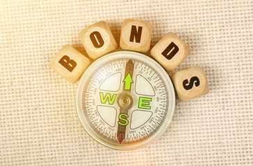 On the table is a compass and cubes with the inscription - BONDS