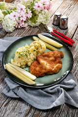 Pork chop served with mashed potatoes and pickled cucumber.