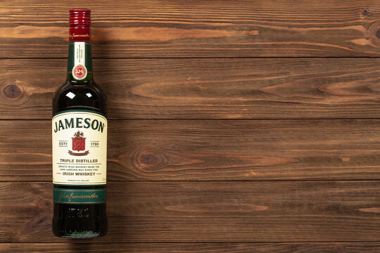 Ternopil, Ukraine - December 08, 2021: A bottle of Jameson Irish whiskey on wooden background with empty space for text