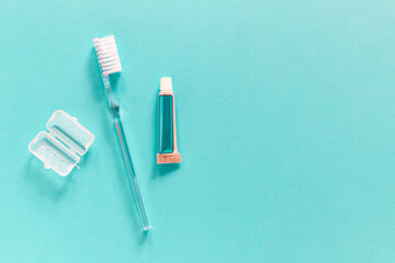 Flatlay of travel set with single use toothbrush and small paste tube on a blue background with copy space for your text. Morning routine while travelling  concept
