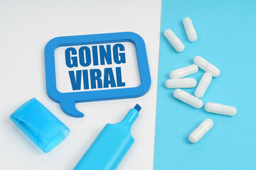 On the white and blue surface are a marker, tablets and a plate inside which the inscription - Going Viral