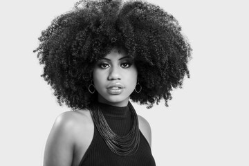 portrait of a young black woman with great afro hair looking at camera.