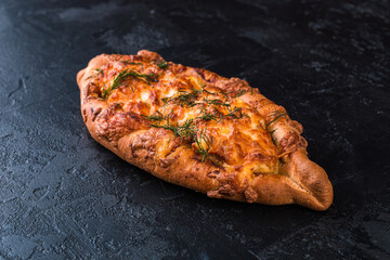 Freshly baked tasty bun on a dark table. Tasty baked goods straight from the bakery. Black background.