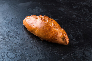 Freshly baked tasty bun on a dark table. Tasty baked goods straight from the bakery. Black background.