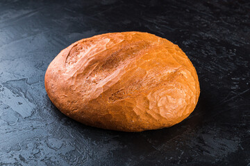 Freshly baked tasty bun on a dark table. Tasty baked goods straight from the bakery. Black background.