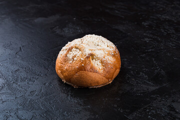 Freshly baked tasty bun on a dark table. Tasty baked goods straight from the bakery. Black...