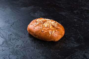 Freshly baked tasty bun on a dark table. Tasty baked goods straight from the bakery. Black background.