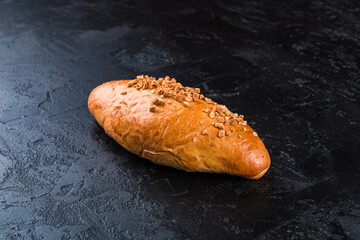 Freshly baked tasty bun on a dark table. Tasty baked goods straight from the bakery. Black...