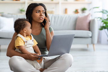Black Mom Using Laptop And Talking On Phone With Baby On Hands