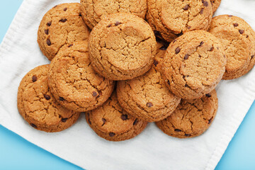 Oatmeal cookies on a blue background and a white napkin top view