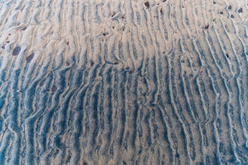 Black sand with traces of waves on the White Sea