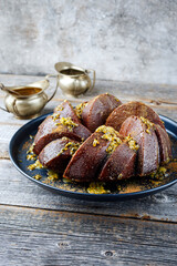 Exotically bundt marble passion fruit rum cake with icing sugar glaze, fresh fruit pulp topping and muscovado brown sugar served as close-up on a plate with copy space