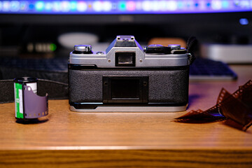 35mm film camera on wood with film and lenses