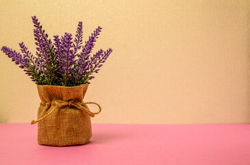 Delicate purple lavender bush in design. Lavender in a pot and a sack of burlap on a yellow background. place for text.