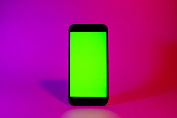 Mobile phone with green screen, smartphone mock up. Neon illumination. Pink and purple color. Flat...