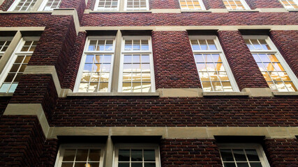 Exterior vintage red brick building and old glass windows background 