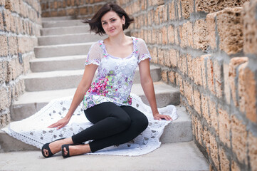 Girl in a knitted sweater on a brick wall background. Crochet flower motifs
