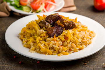 pilaf with beef on white plate close up , uzbek cuisine