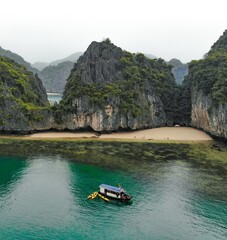 Aerial view from above of limestone hills at Lan Ha Bay, Vietnam during misty morning.
