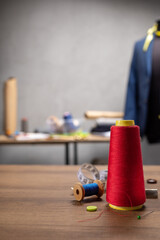 Fototapeta premium Thread spool and needle with sewing tools on table. Concept of clothes atelier workplace