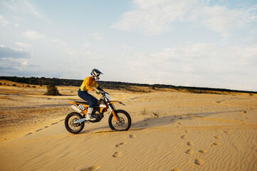 Fototapeta na wymiar Motorcross riding over sand in desert dune