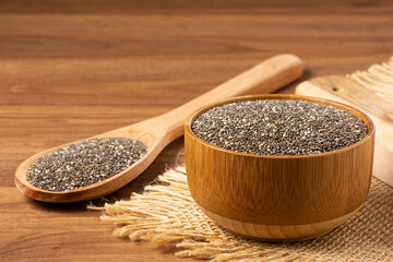 Chia seeds in wooden bowl and wooden spoon.
