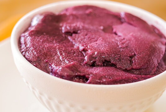 A&ccedil;a&iacute; congelado servido na tigela branca em foto close up com fundo de madeira. Comida brasileira.
