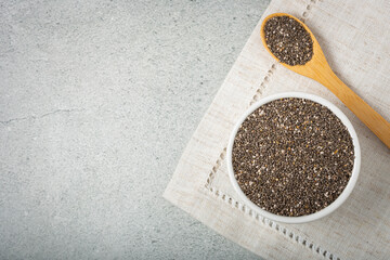 Chia seeds in bowl and wooden spoon on the table.
