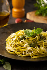 Pasta spaghetti with pesto sauce and basil leaf.