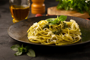 Pasta spaghetti with pesto sauce and basil leaf.