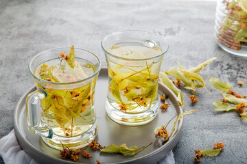 Closeup detail view two cups of linden tea with linden leaf in studio.