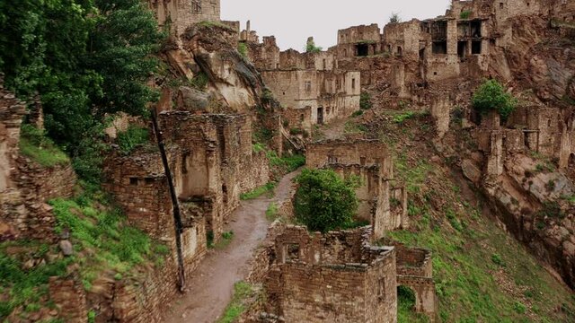 Abandoned in the mountains, the village of Gamsutl. Ghost town, ruins of an old settlement, Impregnable mountain fortress in the Dagestan mountains. Aerial view of an ancient village. 10 bit Video.