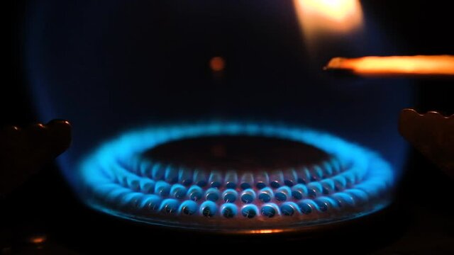 Gas stove being turned on isolated on black background. Natural gas deficit concept. Full HD slow motion video