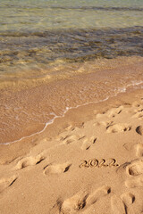 Inscription 2022 on the sand on the shores of the Red Sea.