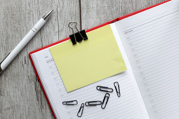 Top view image of an open notebook with blank pages with a yellow sticker, with a financial chart ready for add or layout. Still life, business, stationery or business concept