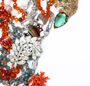 A scattering of antique jewelry with copy-space. Corals, glass, emeralds, bone