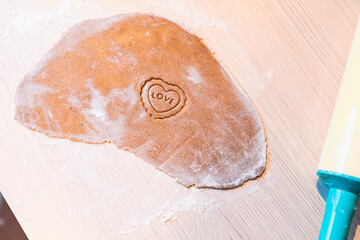 Process of making homemade gingerbread cookies in shape of heart and love