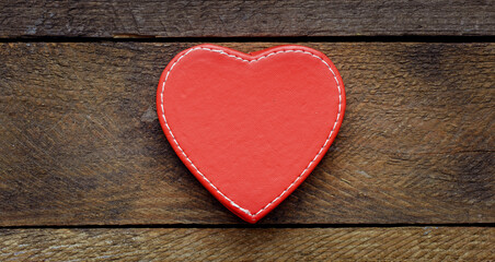 Red heart on a wooden table.