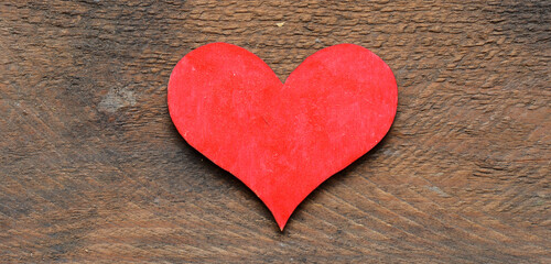 Red heart on a wooden table.
