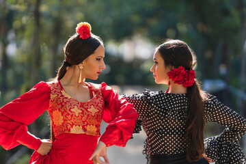 Fototapeta premium Two women in flamenco traditional costume dancing side by side outdoors