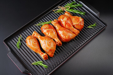 Raw Marinated chicken meat leg swith spices for cooking for BBQ dark background. Top view.Convenience food, precooked.Copy space.