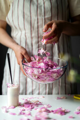 Obraz na płótnie Canvas Woman Making Pink Rose Petal Jam in kitchen