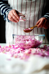 Woman Making Pink Rose Petal Jam in kitchen