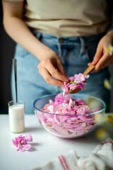 Obraz na płótnie Canvas Woman Making Pink Rose Petal Jam in kitchen