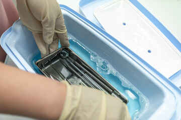 Hands are cleaning medical instruments. Dental office