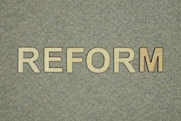 Fototapeta na wymiar text on word reform from wooden letters on a gray table