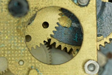 part of the metal mechanism of an old watch made of yellow and black gears